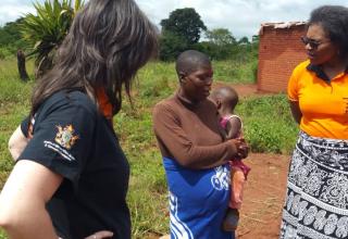 UNFPA Zimbabwe colleagues Rose Katumba and Verena Bruno listen to a pregnant survivor of Cyclone Idai in Chipinge as she narrates how her antenatal care records and medication were swept away by the floods. © UNFPA Zimbabwe